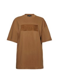 Brązowy oversize t-shirt z krótkim rękawem, okrągłym dekoltem i wytłoczonym napisem "LAMANIA" w prostokątnej łatce na klatce piersiowej.
