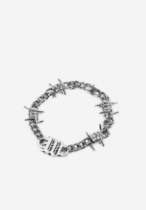 Hõbedast kettrauaga käevõru piikide kujuliste linkidega ja kinnitusdetailiga, esitatud valgel taustal.