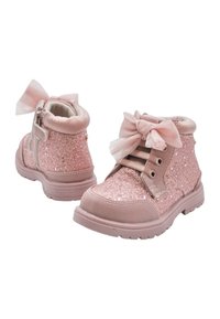 Botines de tobillo rosa con purpurina, con un lazo de tela suave, cierre de cordones al frente y cierre de cremallera. Presentan una suela texturizada y un acabado brillante.