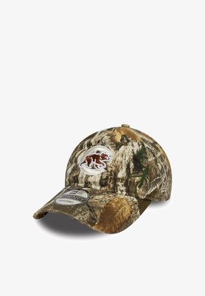 Cappellino da baseball con motivo camouflage marrone e verde e patch con logo di un orso sulla parte anteriore, dotato di cinturino regolabile e visiera curvata.