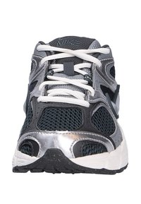 Zapatillas de running Nike para hombres con parte superior de malla gris oscuro, detalles plateados, cordones blancos y una suela exterior de goma negra texturizada.