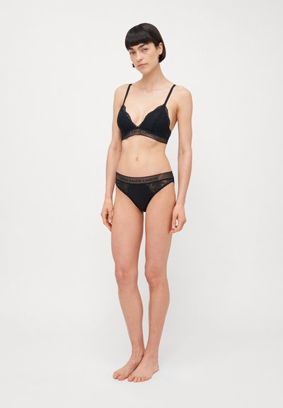 Black lace bralette with adjustable straps, triangle cups, and scalloped edges, paired with matching black lace-trimmed bikini bottom.