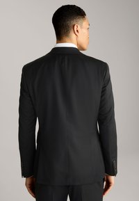 Schwarze Anzugjacke mit taillierter Passform, glatter Textur und Reverskragen. Verfügt über vier Knöpfe an den Manschetten und einen maßgeschneiderten Rückenschnitt.