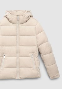 Giacca imbottita beige con cappuccio, design trapuntato, chiusura frontale con cerniera e due tasche laterali con zip. Tessuto morbido e materiale leggero.