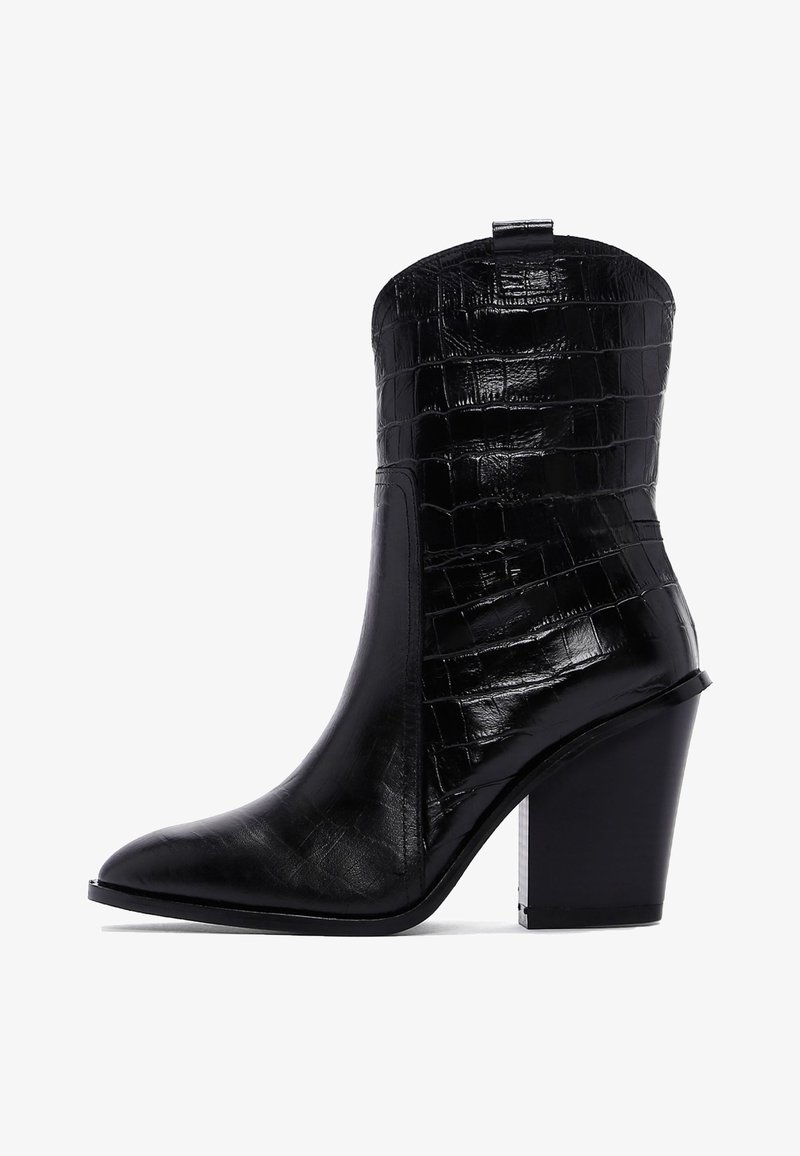 Bottine noire à bout pointu, en cuir gaufré crocodile, dotée d'un talon bloc et d'une languette à l'arrière.
