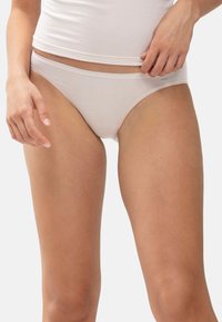 Białe bawełniane bikini z miękkim pasem, minimalistycznym designem i gładką teksturą, z małą metką marki z boku.