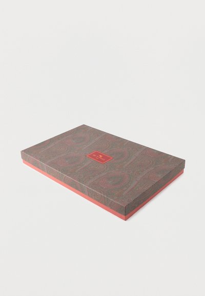 Boîte cadeau rectangulaire avec un couvercle à motif cachemire dans des tons de marron et vert, base de couleur corail et une étiquette rouge au centre.