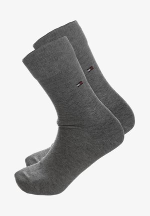 Grijze katoenen sokken met een ribbelstructuur, enkellengte en een klein gekleurd logo aan de zijkant. Gladde afwerking zonder zichtbare patronen.