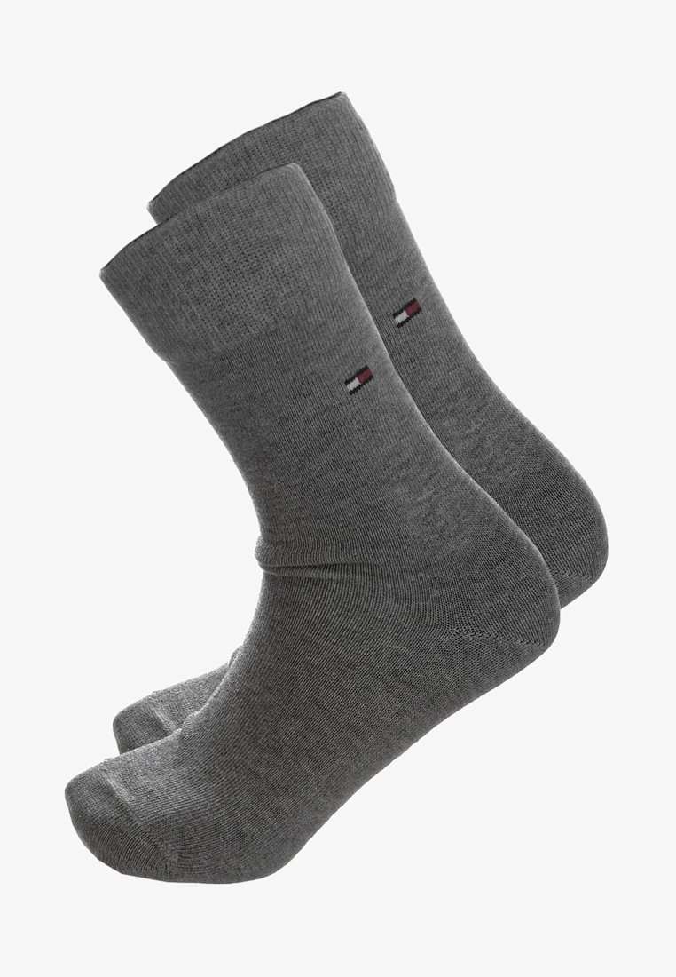 Chaussettes en coton grises avec une texture côtelée, hauteur cheville, et un petit logo coloré sur le côté. Fini lisse sans motifs visibles.