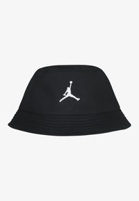Svart bøttehatt laget av stoff, med en hvit brodert Jumpman-logo foran, bred brem og strukturert design.