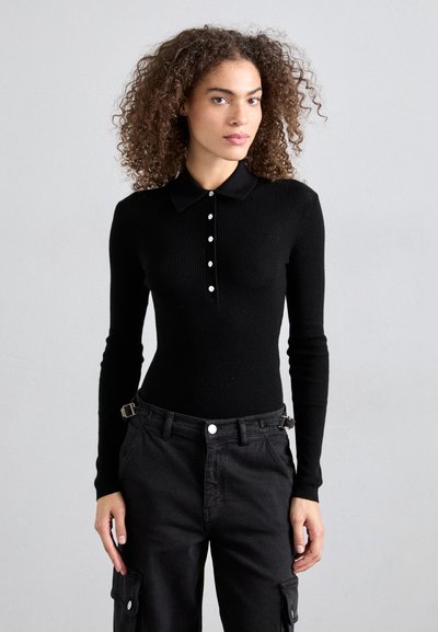 Schwarzes, geripptes Langarm-Polohemd mit Kragen, einer Knopfleiste mit fünf Knöpfen und einer figurbetonten Silhouette, kombiniert mit hoch taillierten schwarzen Cargo-Hosen.