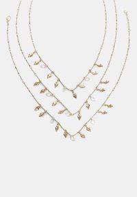 Collana a strati in tono dorato caratterizzata da tre filamenti con ciondoli a forma di foglia e dettagli in cristallo, che mettono in risalto un design delicato e texturizzato.