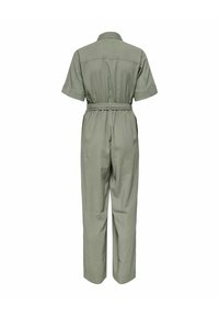 Combinaison vert sauge à manches courtes avec col, taille élastique, ceinture et pantalons droits vue de dos sur fond blanc.