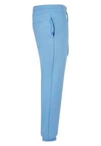 Ljusblå sweatpants i mjukt tyg, med justerbart midjeband, sidofickor och ribbade muddar vid anklarna.