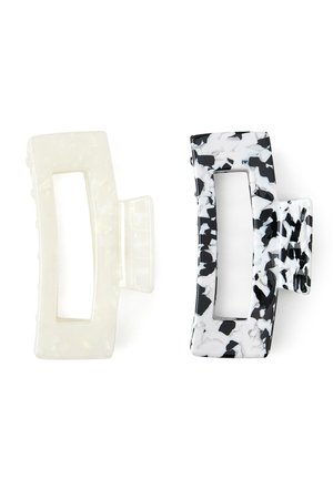 Dos clips de cabello rectangulares con centros abiertos, uno sólido translúcido blanco y el otro con patrón marmoleado en blanco y negro.