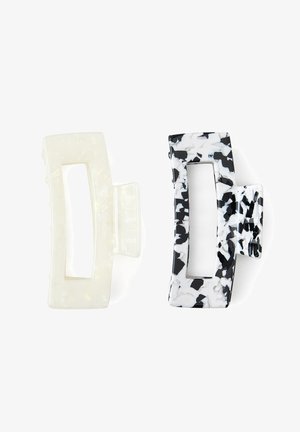 Dos clips de cabello rectangulares con centros abiertos, uno sólido translúcido blanco y el otro con patrón marmoleado en blanco y negro.