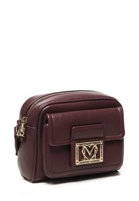 Borsa a tracolla in pelle marrone scuro, compatta, con tasca frontale con pattina e placca logo a forma di cuore in tonalità oro, con chiusure a zip.