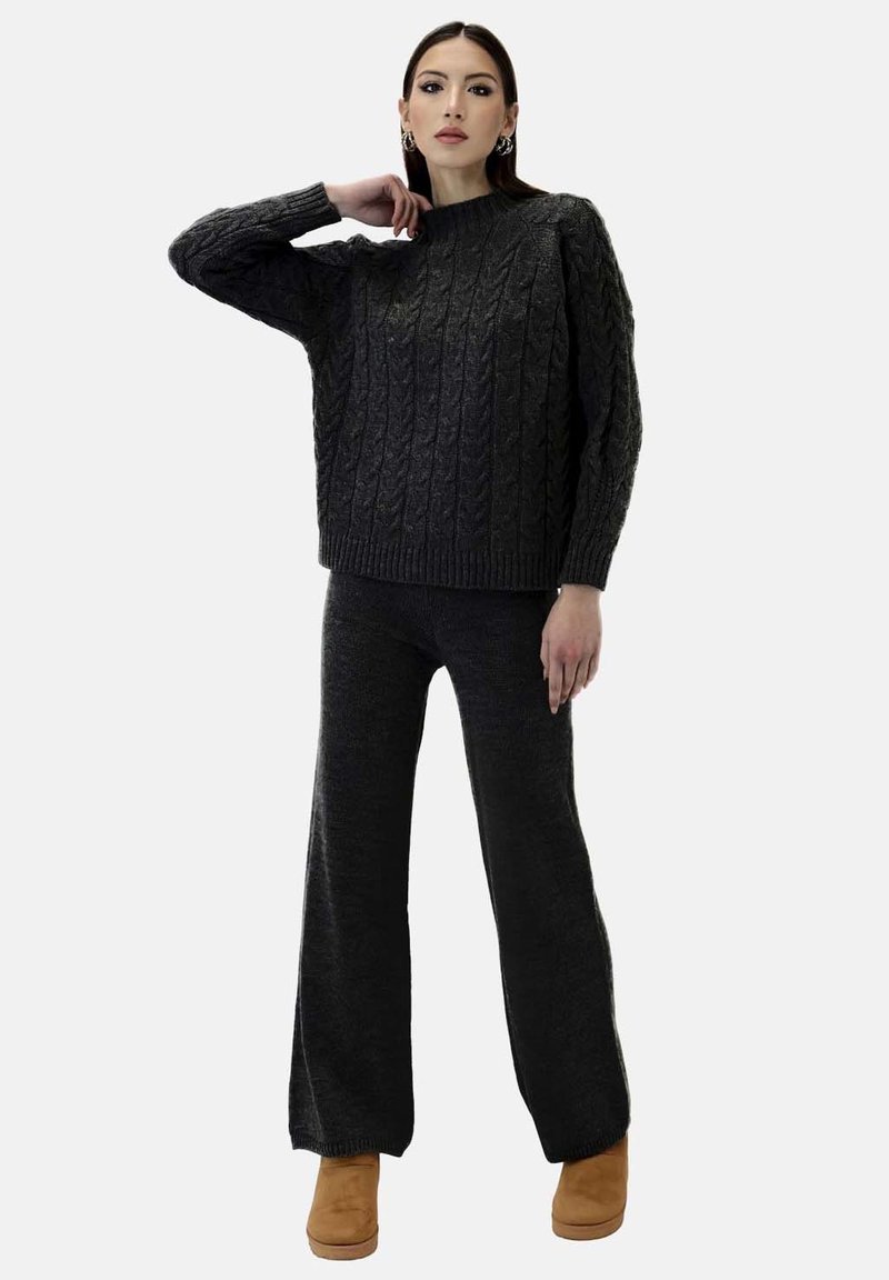 Suéter de punto grueso en gris oscuro con un cuello alto, combinado con pantalones de pierna ancha a juego. El conjunto presenta una textura suave y acogedora.