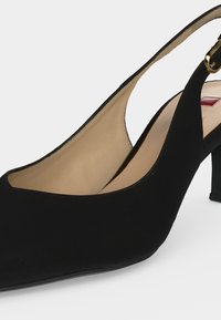Μαύρο σαουέτ γόβα slingback με μεσαίο τακούνι, μυτερή μύτη, μπεζ εσωτερική επένδυση και χρυσή αγκράφα στο λουράκι.