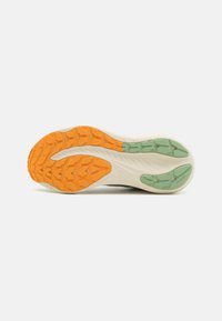 Semelle de chaussure présentant une palette de couleurs orange, verte et beige, avec du caoutchouc texturé pour l'adhérence, des motifs moulés et des rainures de flexion pour la performance.