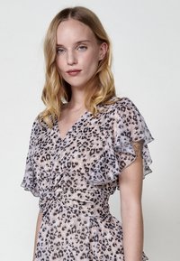 Leichtes, gemustertes Kleid mit einer geknoteten Taille; verfügt über Rüschensleeves in Rosa- und Brauntönen mit einem Leopardenmuster.