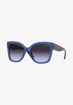 Blauwe, oversized zonnebrillen met gradient lenzen. Transparante blauwe montuur en een luipaardprint op de pootjes. Logo gedrukt op het montuur.