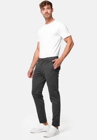 Gray tailored trousers with a slim fit, cotton blend fabric, front pockets, and a flat front, paired with a plain white t-shirt and white sneakers.