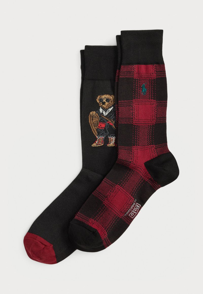 Two pairs of mid-calf socks: one black with red toes featuring a teddy bear in sportswear, the other black and red plaid with a green logo.