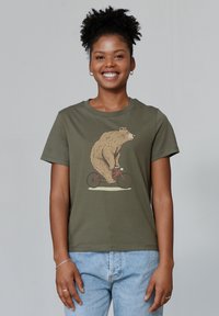 Olijfgroene t-shirt met een illustratie van een beer die op een rode fiets rijdt. Korte mouwen, van katoen materiaal en een ontspannen pasvorm.