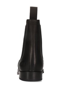 Botín negro de cuero a la altura del tobillo con tira para tirar, paneles laterales elásticos y tacón bajo apilado, mostrado desde la parte trasera sobre un fondo blanco.