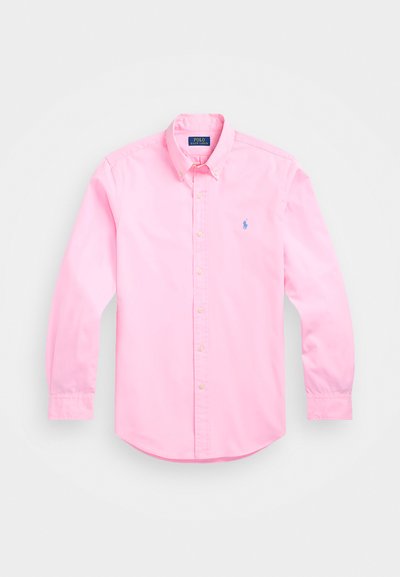 Ροζ ανοιχτό πουκάμισο με μακριά μανίκια, με κολάρο που κουμπώνει, μαργαριταρένια κουμπιά και μικρό μπλε λογότυπο στο στήθος. Απαλή βαμβακερή ύφανση, καμπυλωτό στρίφωμα.