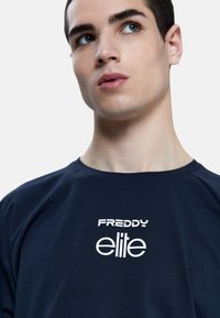 T-shirt in cotone blu navy con la scritta "FREDDY" e "elite" in bianco sul davanti, con scollatura rotonda classica e maniche corte.