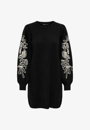 Mustapaita, jossa on pitkät hihat. Ominaisuuksiin kuuluu valkoinen brodeeraus, jossa on orgaanisia muotoja hihojen varrella. Ribbaus kaula-aukossa ja hihoissa.