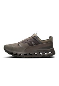 Chaussures de sport en vert foncé et gris, avec une tige en mesh, une semelle rembourrée et des découpes distinctives le long de la semelle extérieure pour la ventilation.