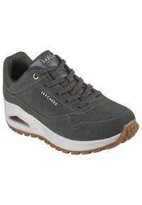 Zapatilla de ante gris con textura perforada, diseño con cordones, cuello acolchado, media suela blanca y suela de goma color caramelo. Logo en la lengüeta.