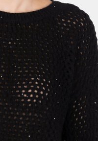 Maglione nero a maglia con un motivo a rete largo e aperto, dotato di un colletto a coste. Sottile scintillio è visibile in tutto il tessuto.