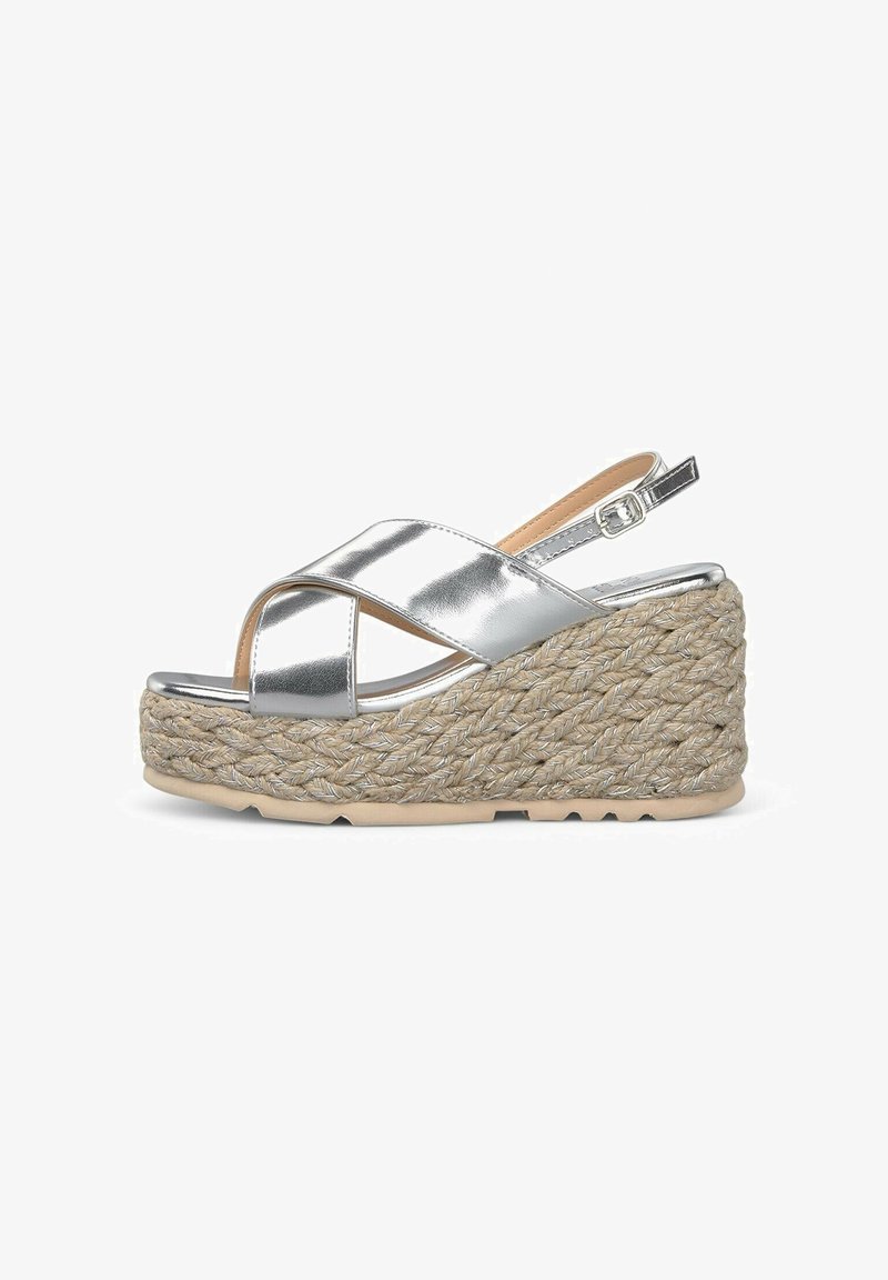 Zilveren metallic wedge sandalen met kruislings gespen, geweven jute structuur, rubberen zool en verstelbare slingback gespsluiting.