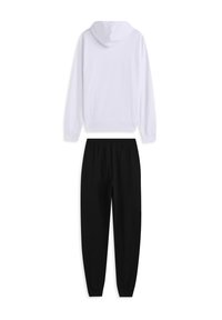 Sudadera con capucha en algodón blanco sobre pantalones jogger de algodón negro, con cintura elástica y puños ajustados para un ajuste relajado.