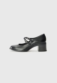 Black leather Mary Jane-style shoe with a rounded toe, two adjustable straps, and a chunky heel. Smooth texture with minimal accents.