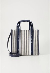 Saco de lona às riscas azul-marinho e branco, feito de tecido resistente, com alças duplas e uma tira de ombro removível com detalhes do logotipo.