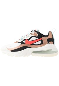 Nike Air Max teniska s kombinací bílých, černých a hnědých materiálů, vybavená výrazným červeným logem, průhlednou podrážkou a texturovanými designovými prvky.