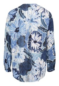 Blouse à manches longues avec grand imprimé floral bleu et blanc, présentant des fleurs abstraites et des accents bleu foncé sur un fond clair.