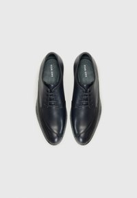 Navy leather dress shoes with a smooth finish, rounded toe, and five lace eyelets. Features a subtle stitched pattern along the seams.