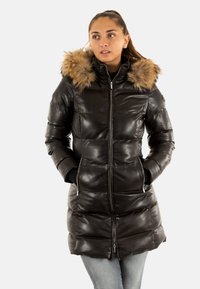 Chaqueta acolchada de cuero negro con capucha forrada de piel, cierre de cremallera en la parte delantera y dos bolsillos laterales. Presenta secciones acolchadas para aislamiento.