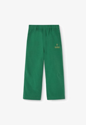 Pantalon vert à jambes larges avec taille élastique et petit logo jaune portant la mention "The Animals Observatory" sur le devant côté droit.