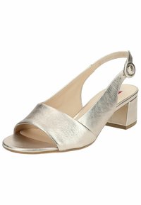 Metallic sølv slingback sandal med åben tå, der har en bred strop og en blokhæl. Glat tekstur med cirkulært hardware-detail.