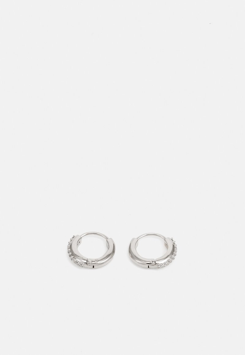 Orecchini a cerchio in argento con una finitura liscia, caratterizzati da una fila di piccole pietre trasparenti su un lato. Design circolare con chiusura sicura.