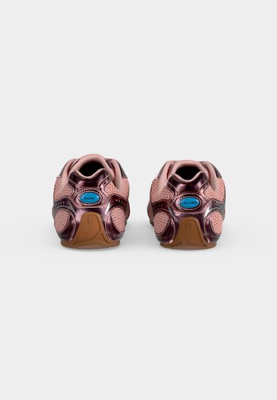 Paire de baskets roses et métalliques vues de dos, étiquetées "Marc" sur la chaussure gauche et "Jacobs" sur la chaussure droite.