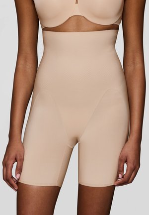 Shorts modellanti beige a vita alta, realizzati in un tessuto liscio ed elasticizzato con un sottile motivo a zigzag. Lunghezza a metà coscia.