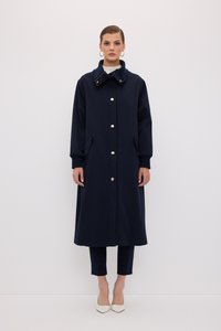 Marineblå lang frakke med ståkrave, med gyldne knapper, sidelommer og en afslappet pasform. Glat stof og minimalistisk design.